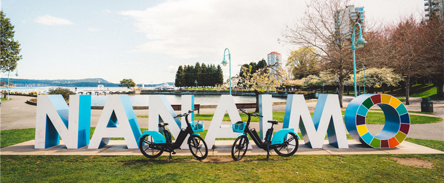 Evolve e-bikes parked in front of the Nanaimo park sign