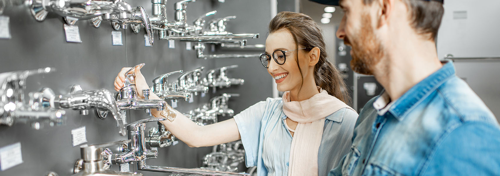 woman at a fixture shop trying out faucets
