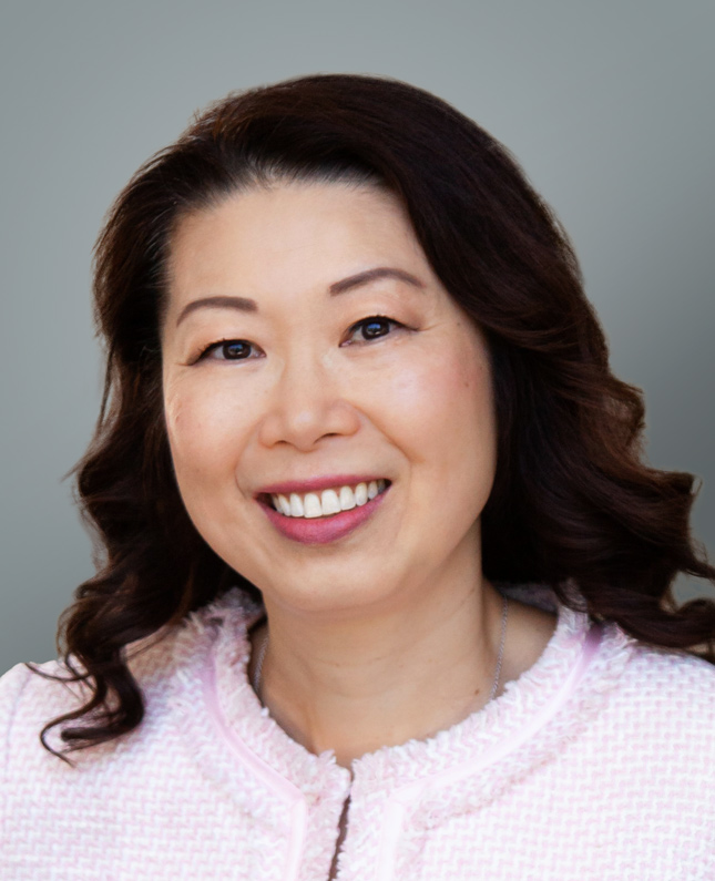 Headshot of Gigi Chen-Kuo smiling wearing a pink jacket.
