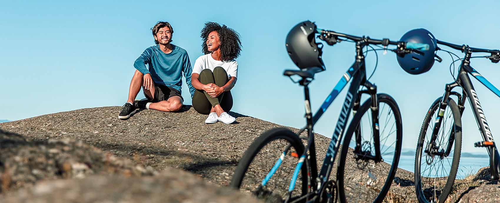 Two hikers sitting on a hill with their bikes