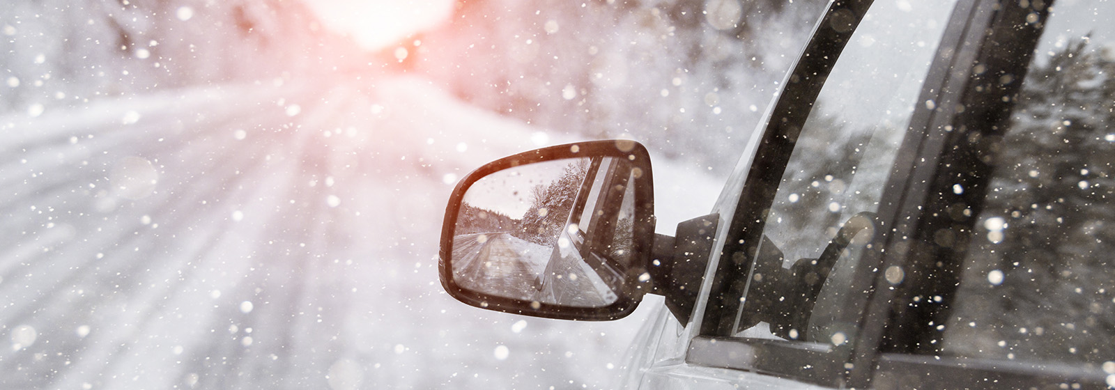 car driving down snowy road