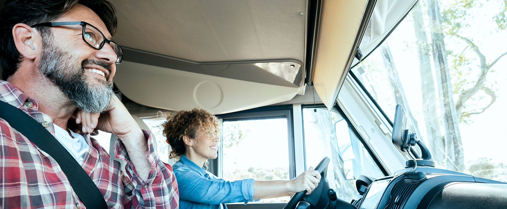 Woman driving a camper van with happy man on passenger seat
