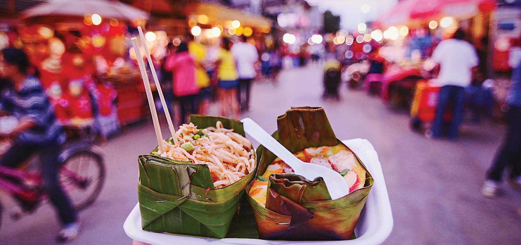 Food festival market with two meals in banana leaf containers