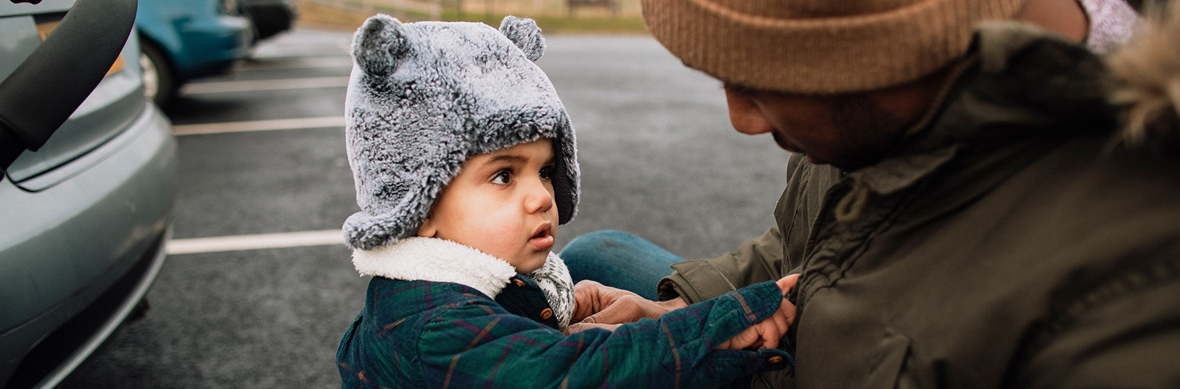 toddler putting on his coat