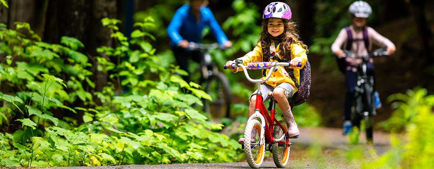 young girl cycling on trail