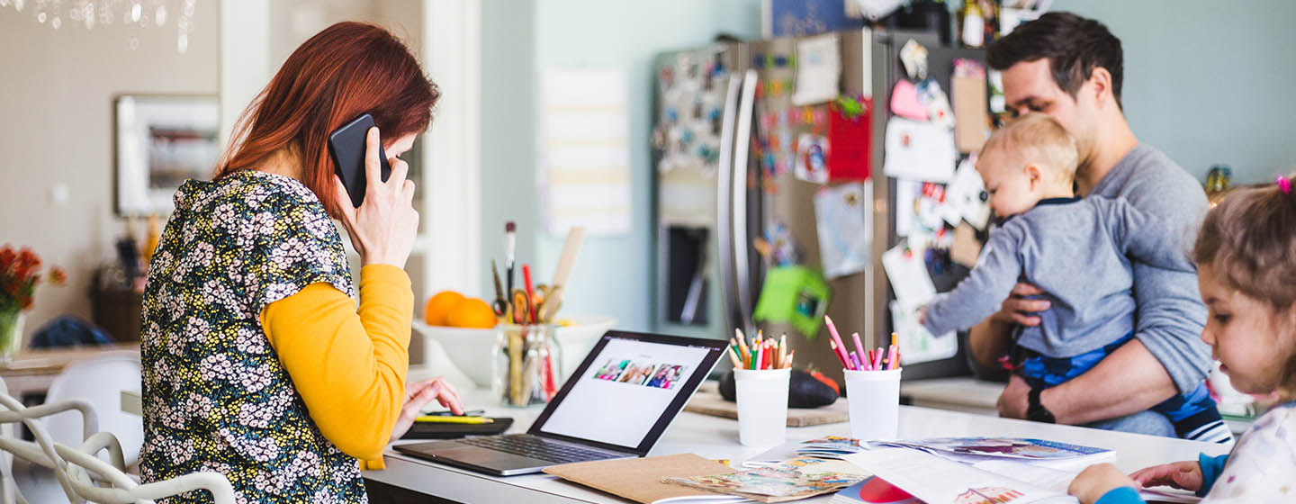 woman on the phone working from home with family