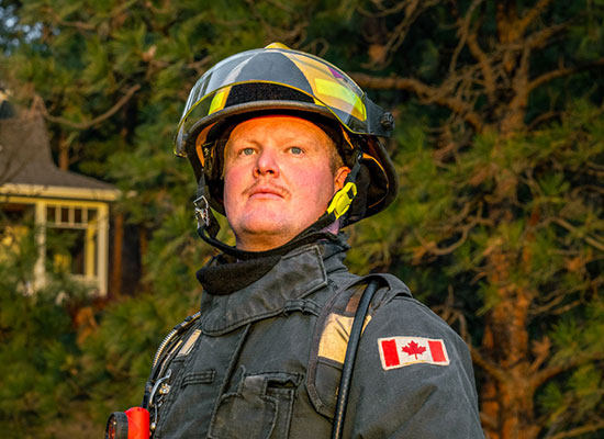 Firefighter standing proudly facing the sun during sunrise