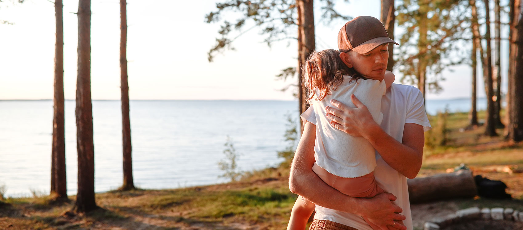 Dad comforts and hugs Daughter during a pine forest walk