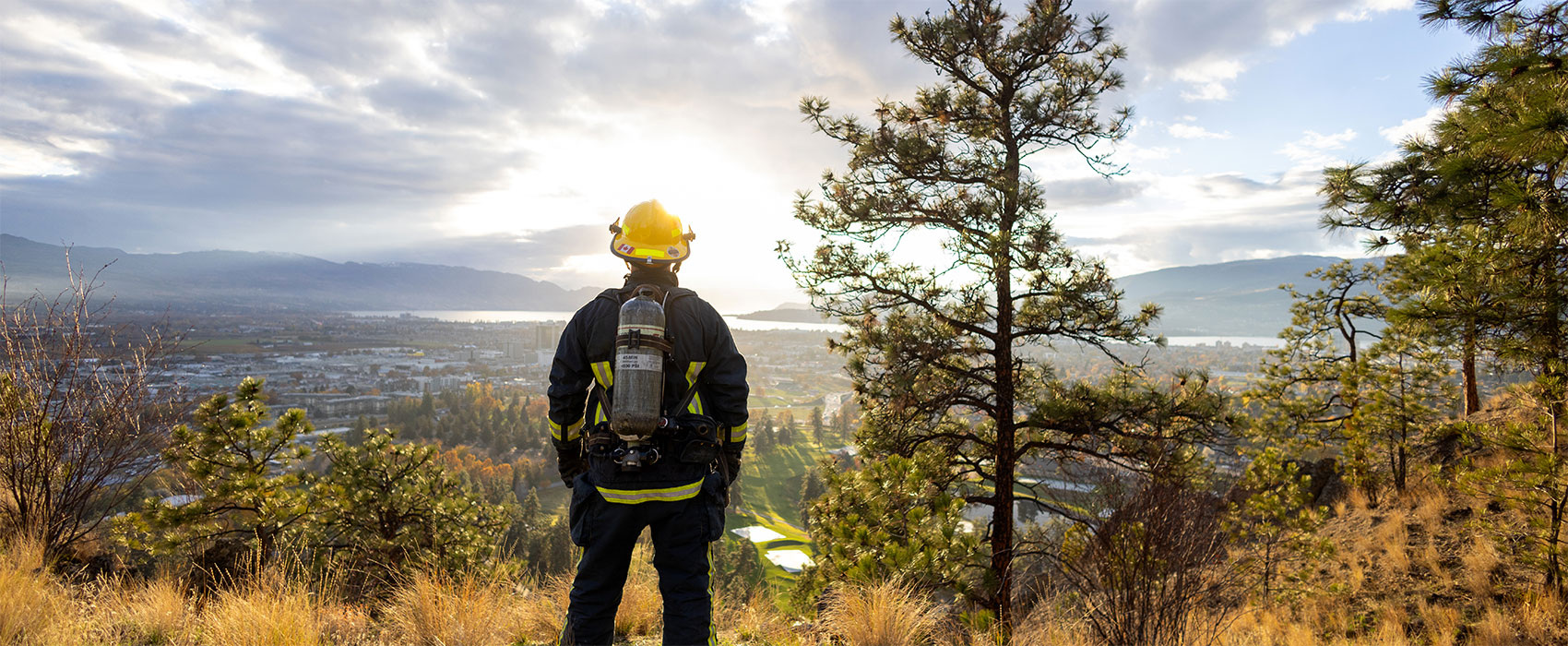 firefighter is looking out over the city from mountains