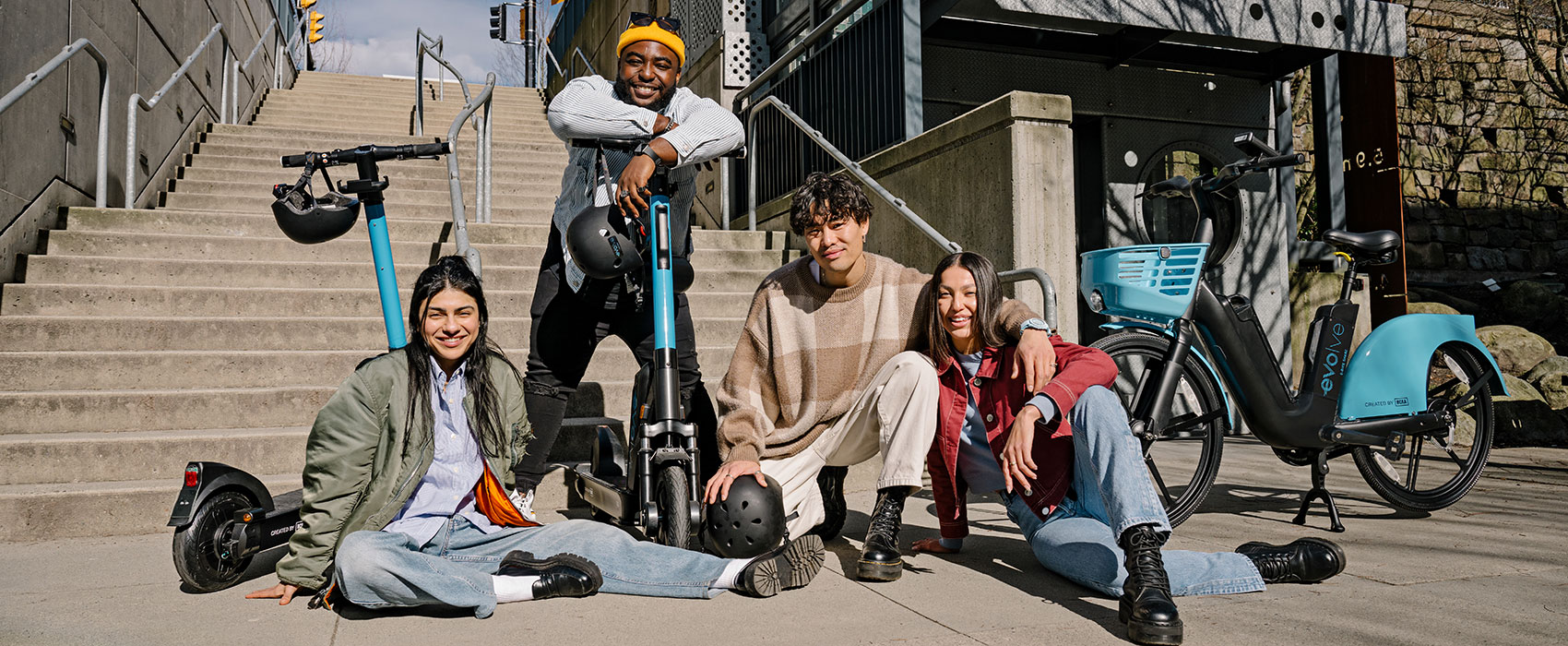 Friends posing together with Evolve e-bikes and scooters
