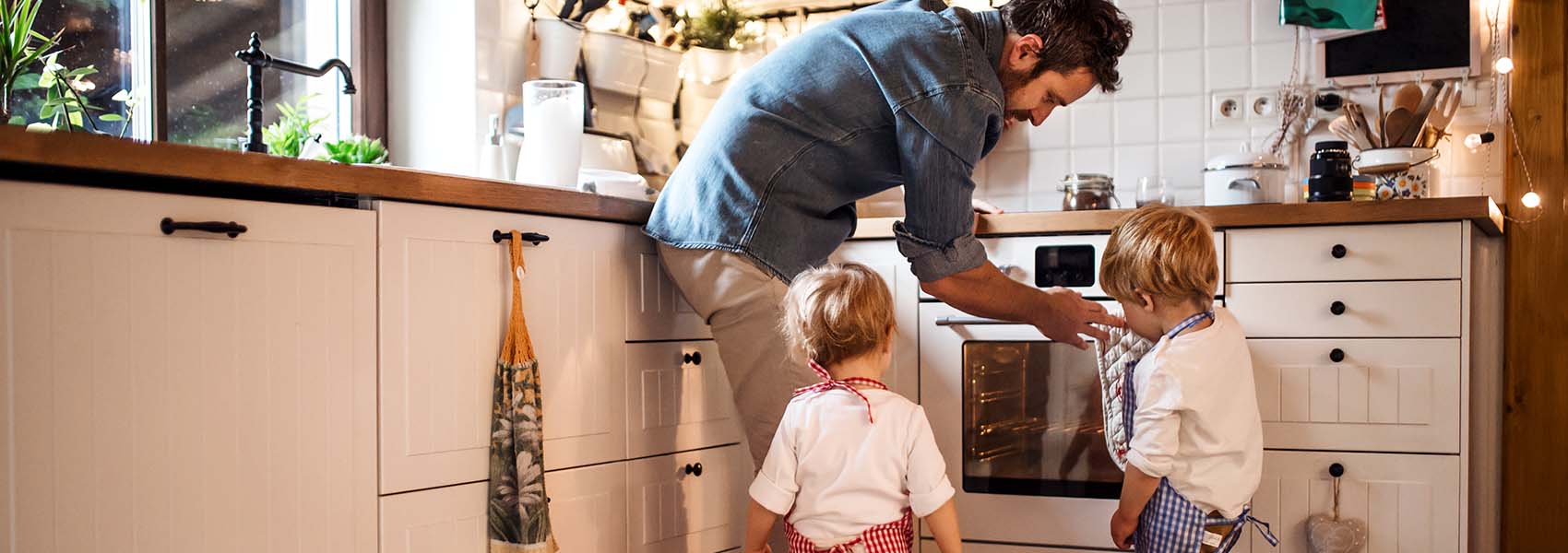 A man with son and daughter at home, making cakes