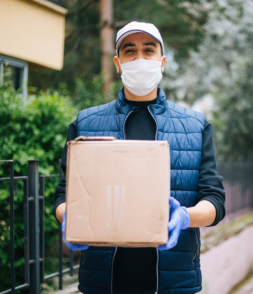 man wearing protective mask and gloves holding box