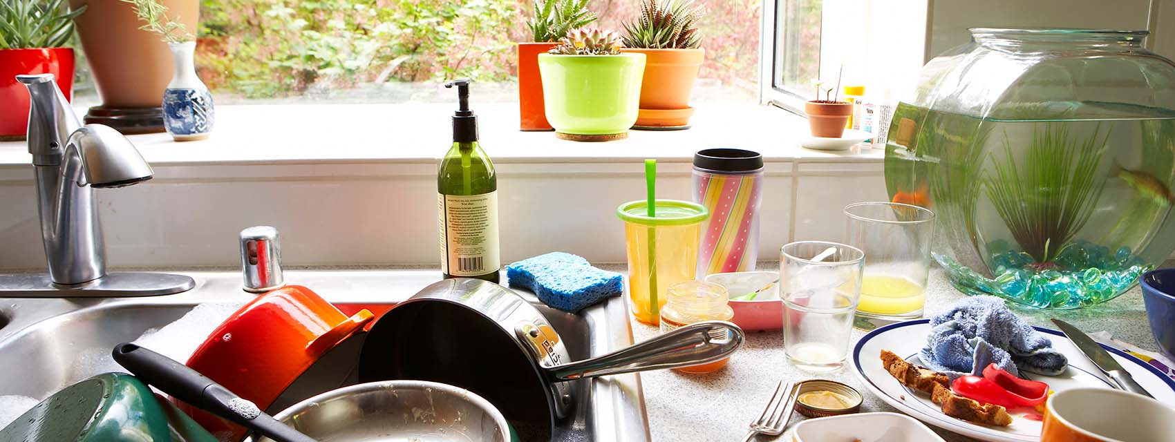 Dirty dishes piled in kitchen sink