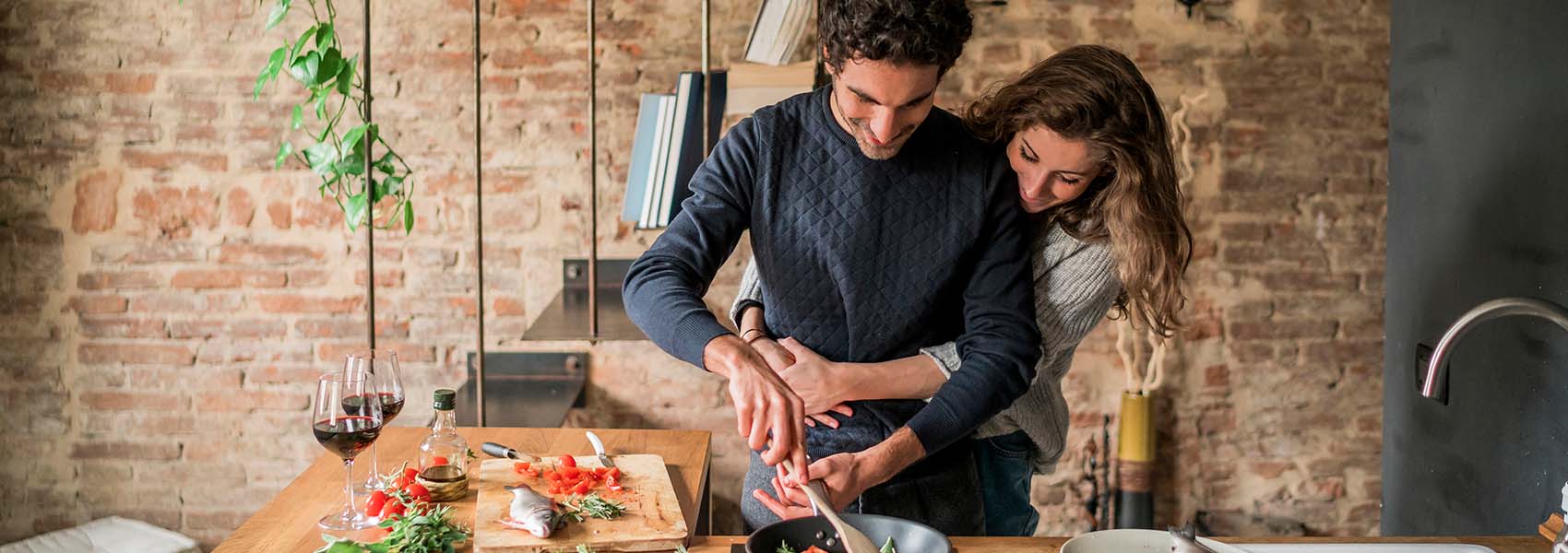 Young couple cooking fish cuisine at kitchen counter