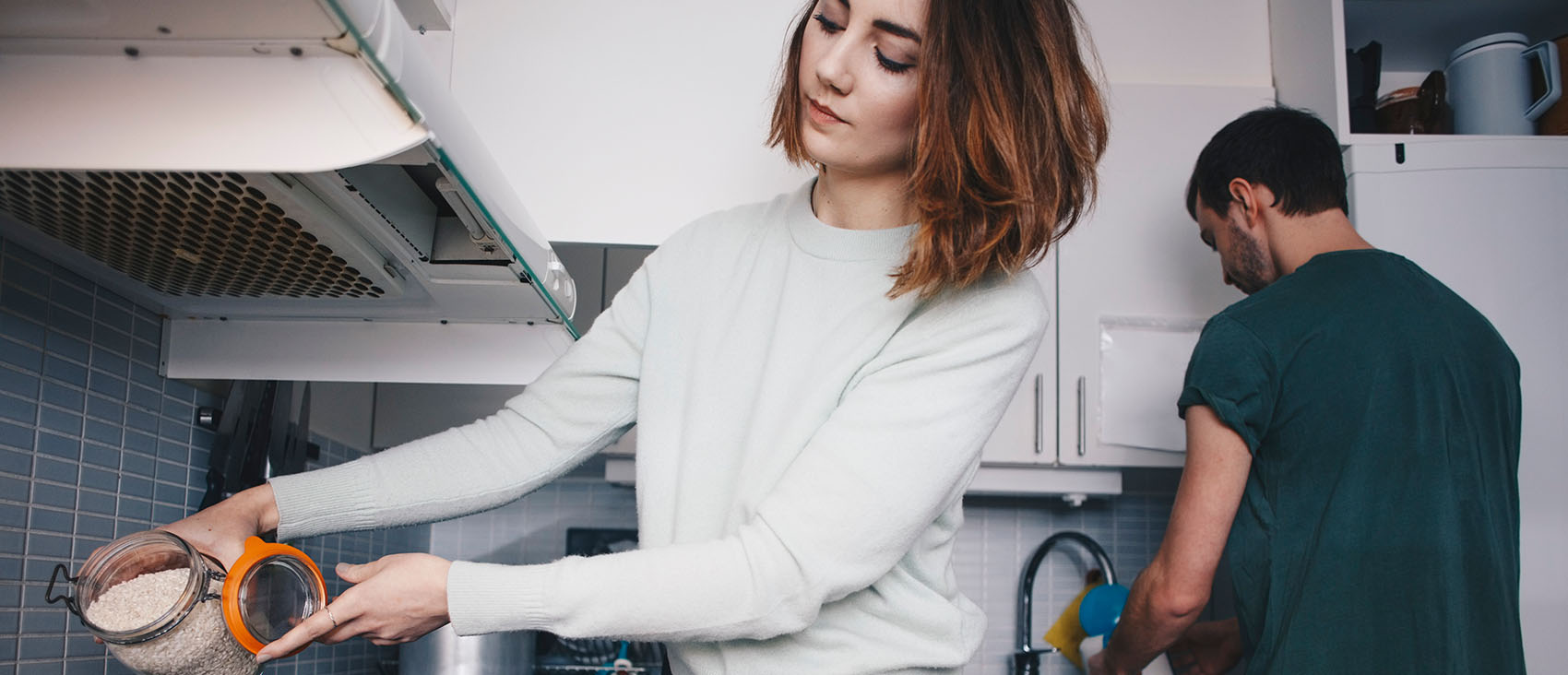 Young roommates preparing food in kitchen