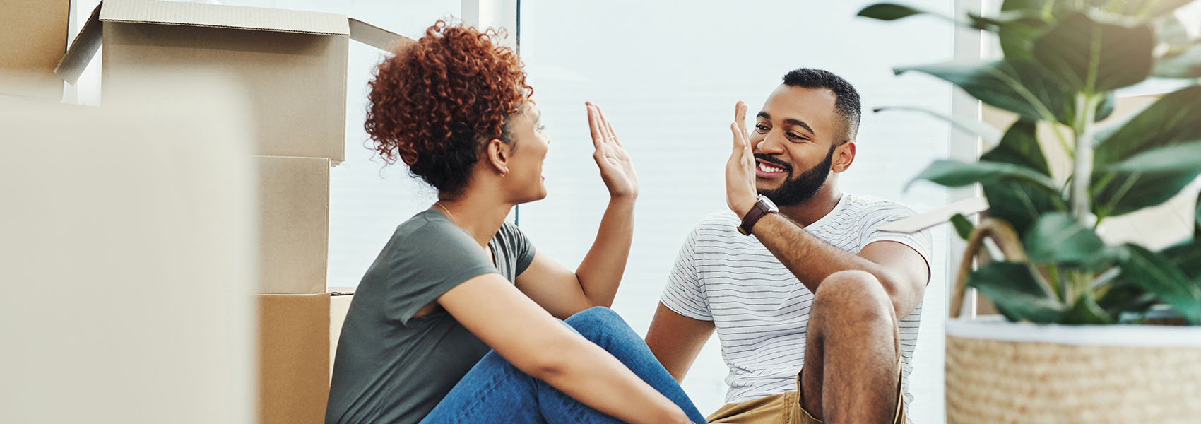 couple giving each other a high five while moving house