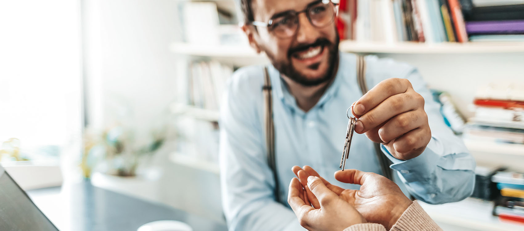 Real estate agent passing keys to his client