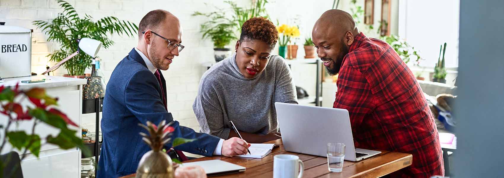 Couple listening to financial advisor at home with laptop