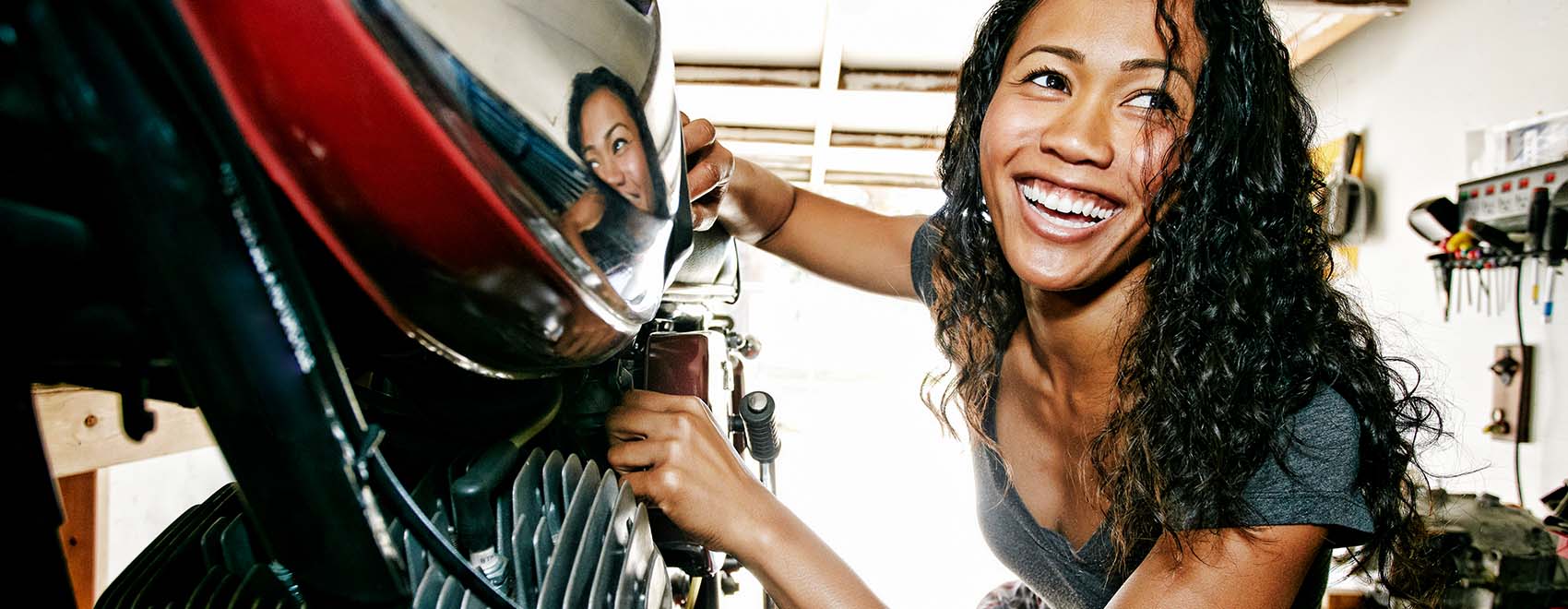 woman repairing motorcycle in garage