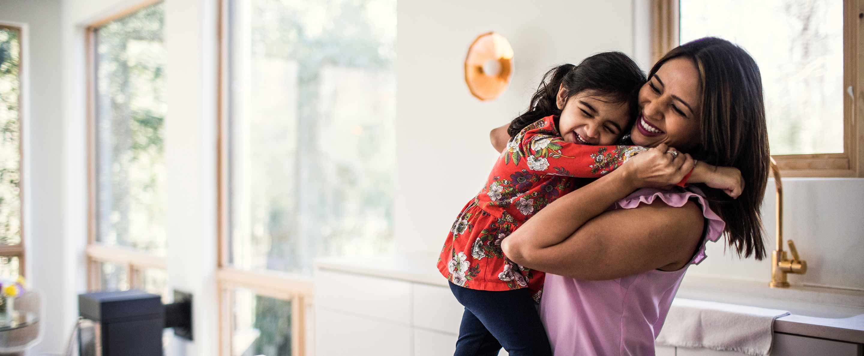 mother and daughter embracing in the kitchen