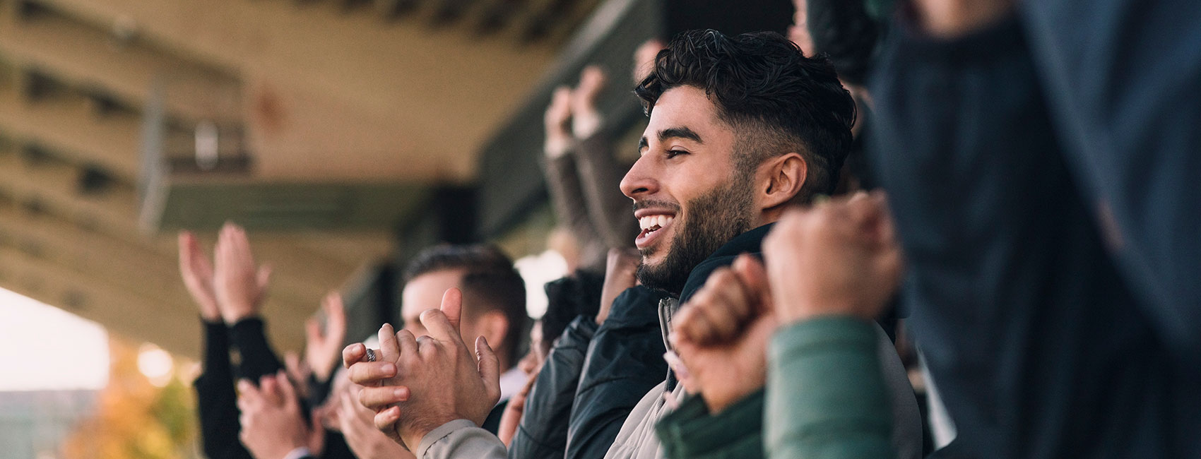 Crowd of sports fans cheering during a match in stadium