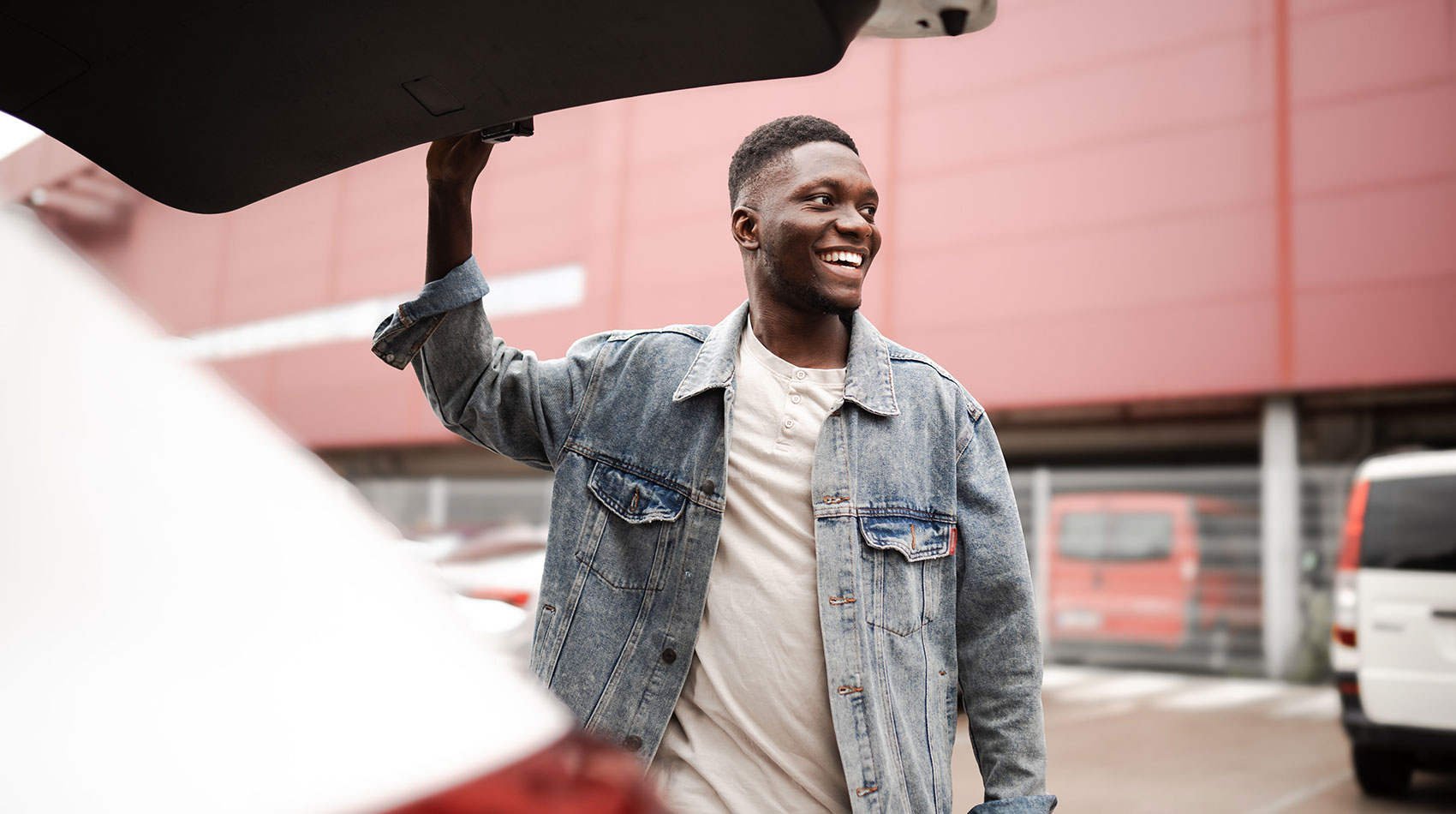 Man in the parking lot closing car trunk