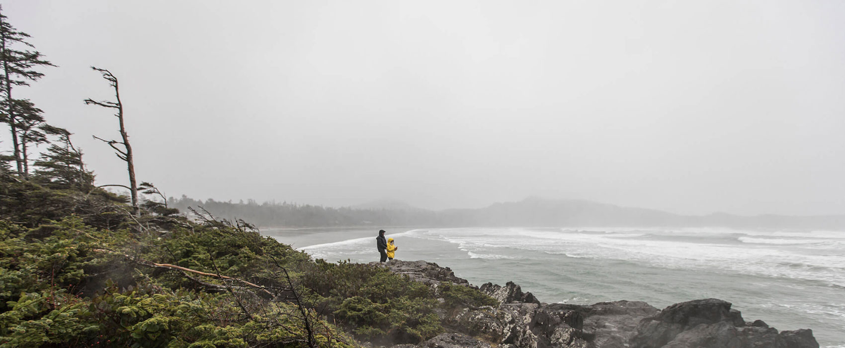 Couple experiencing stormy winter weather by beach
