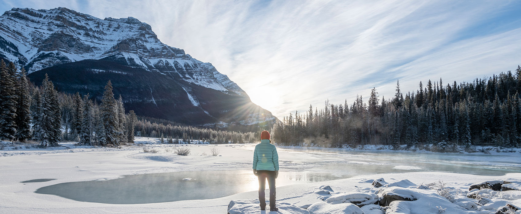 Woman solo hikes in winter through snowy mountains
