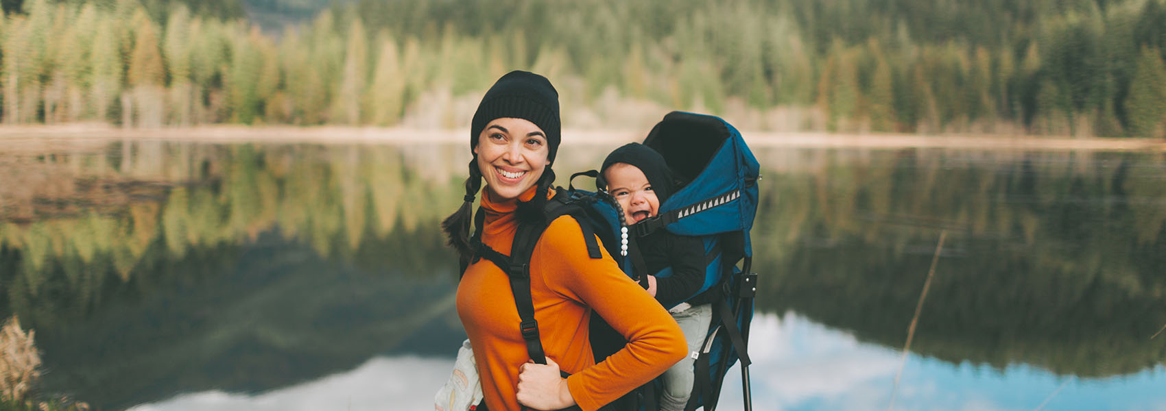 mother with baby standing by lake