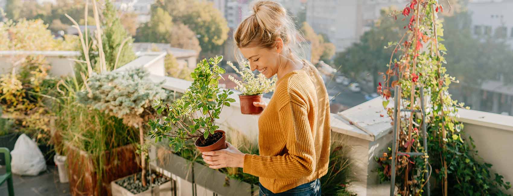 woman holding plants in her outdoor garden