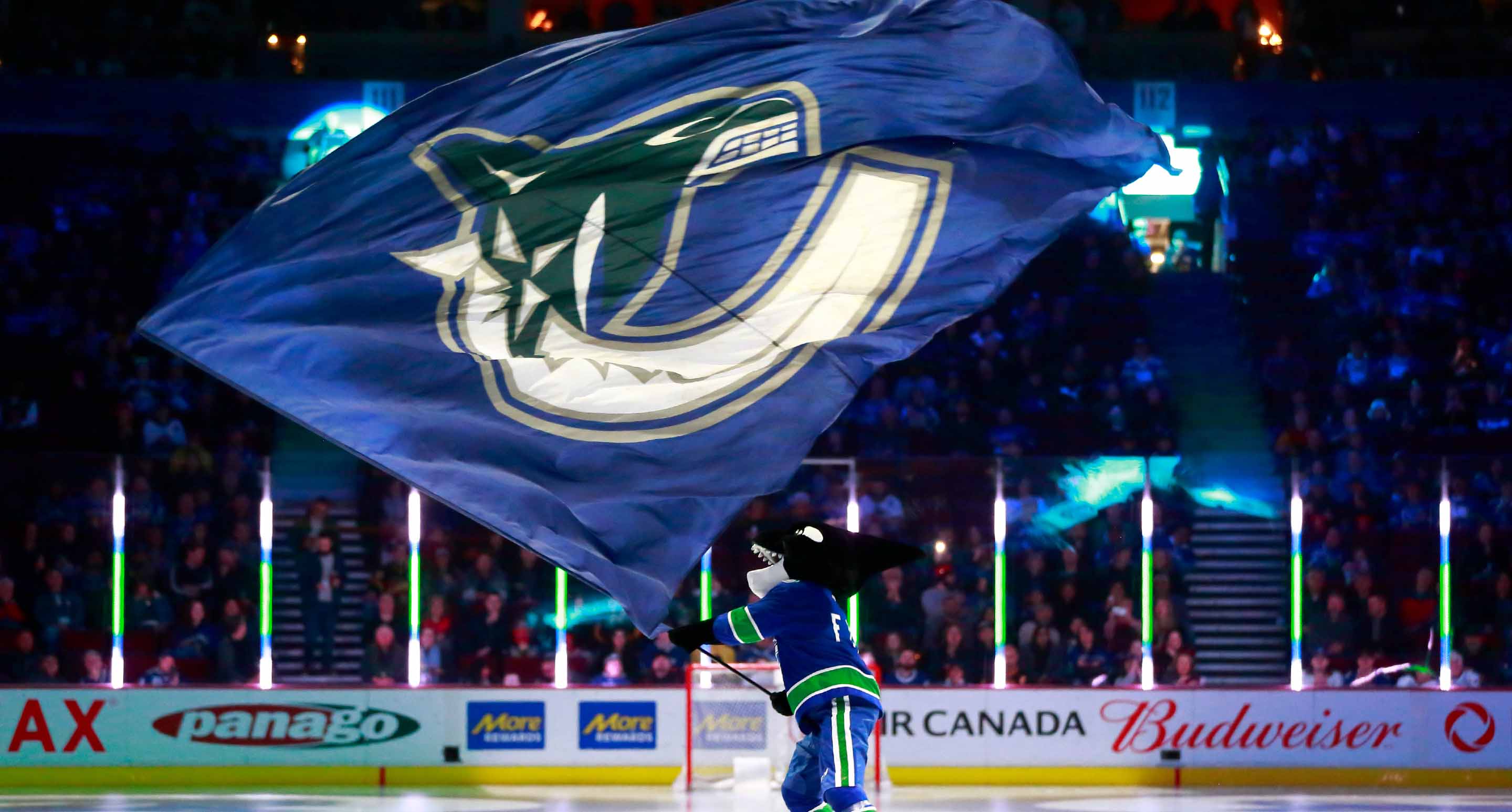 Canucks mascot Finn waving a Canucks flag