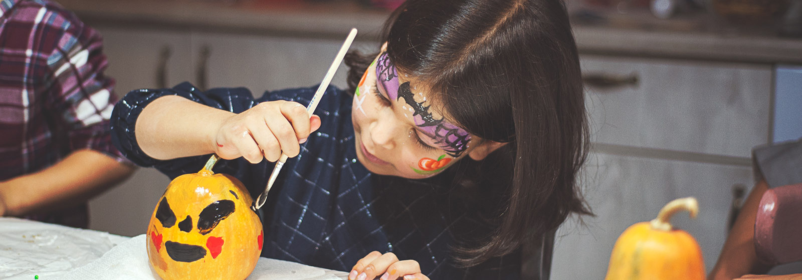 girl painting on small pumpking