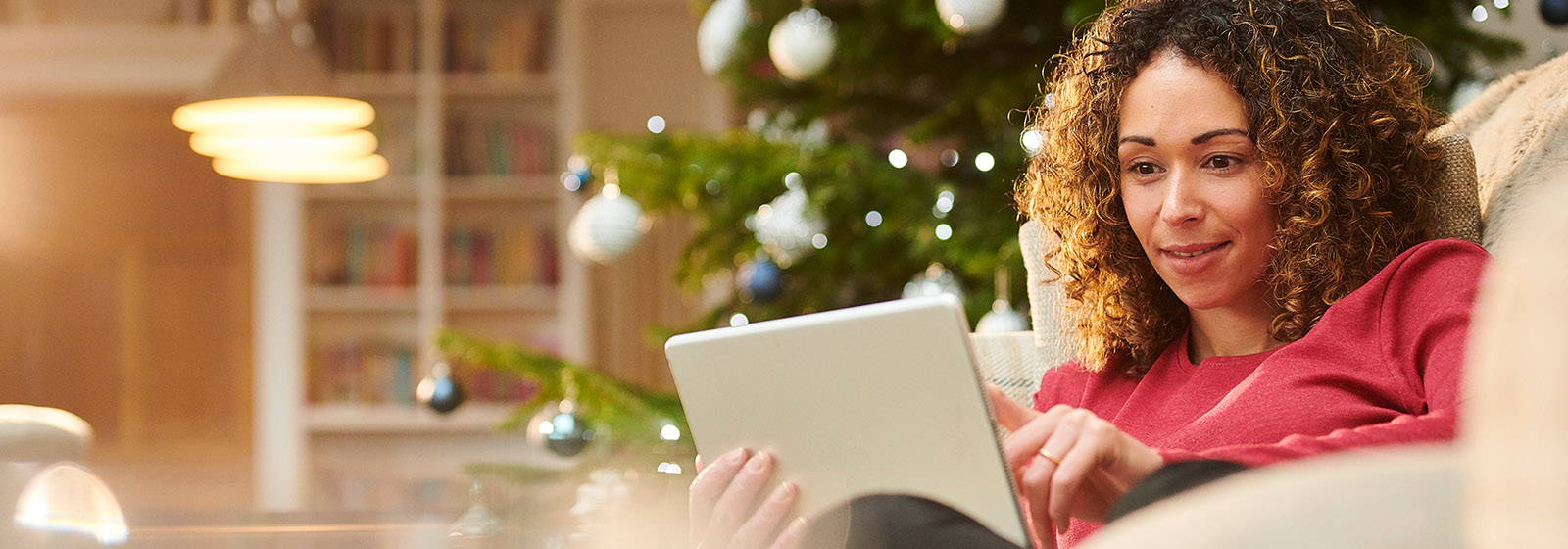 woman sitting on couch looking at tablet