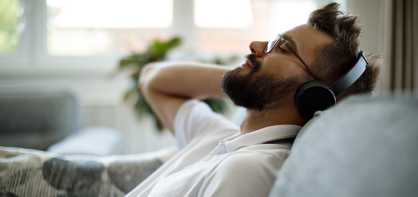 man wearing headphones relaxed on sofa