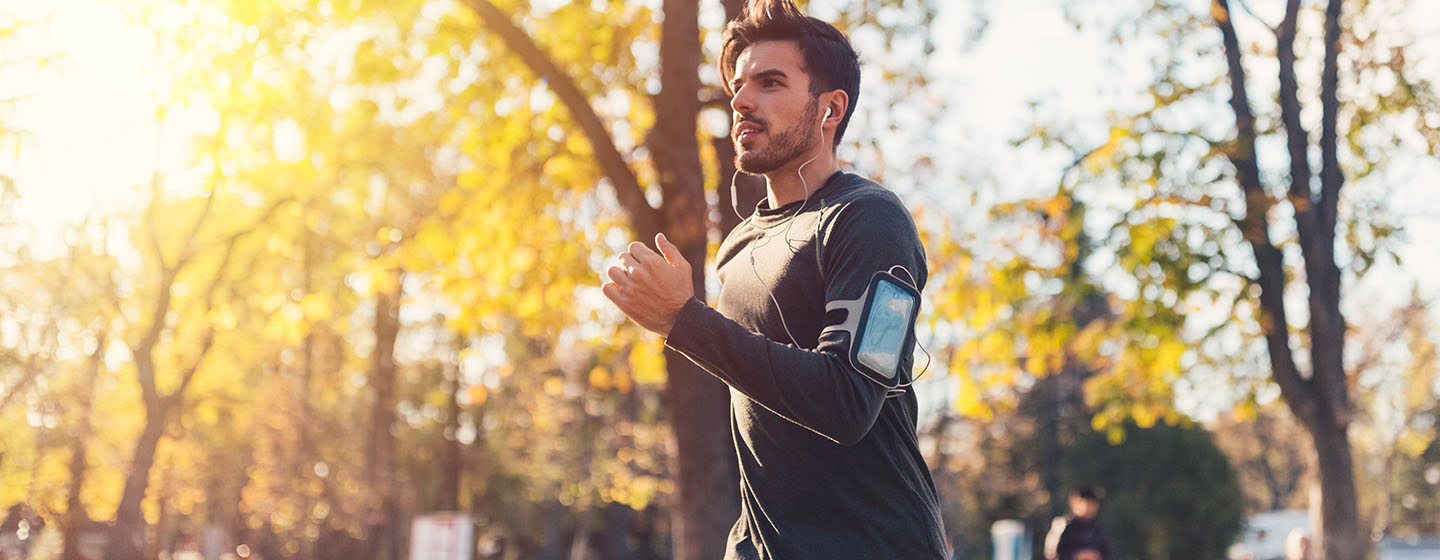 man running with fitness tech gear on arm