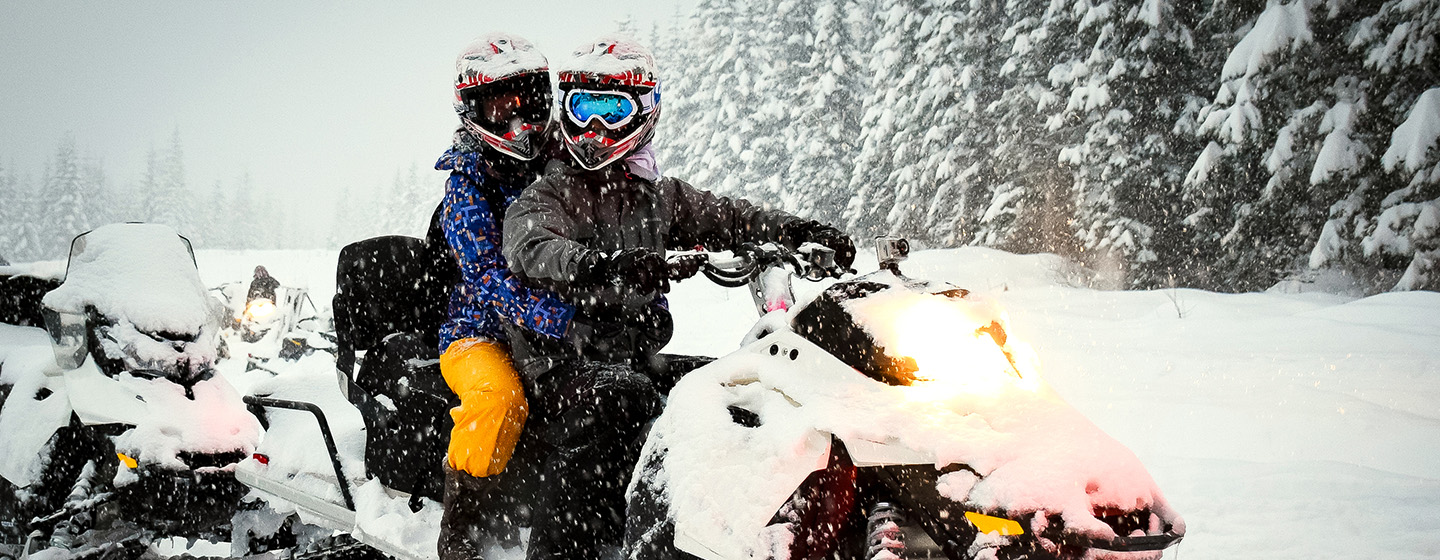 riders on snow mobile