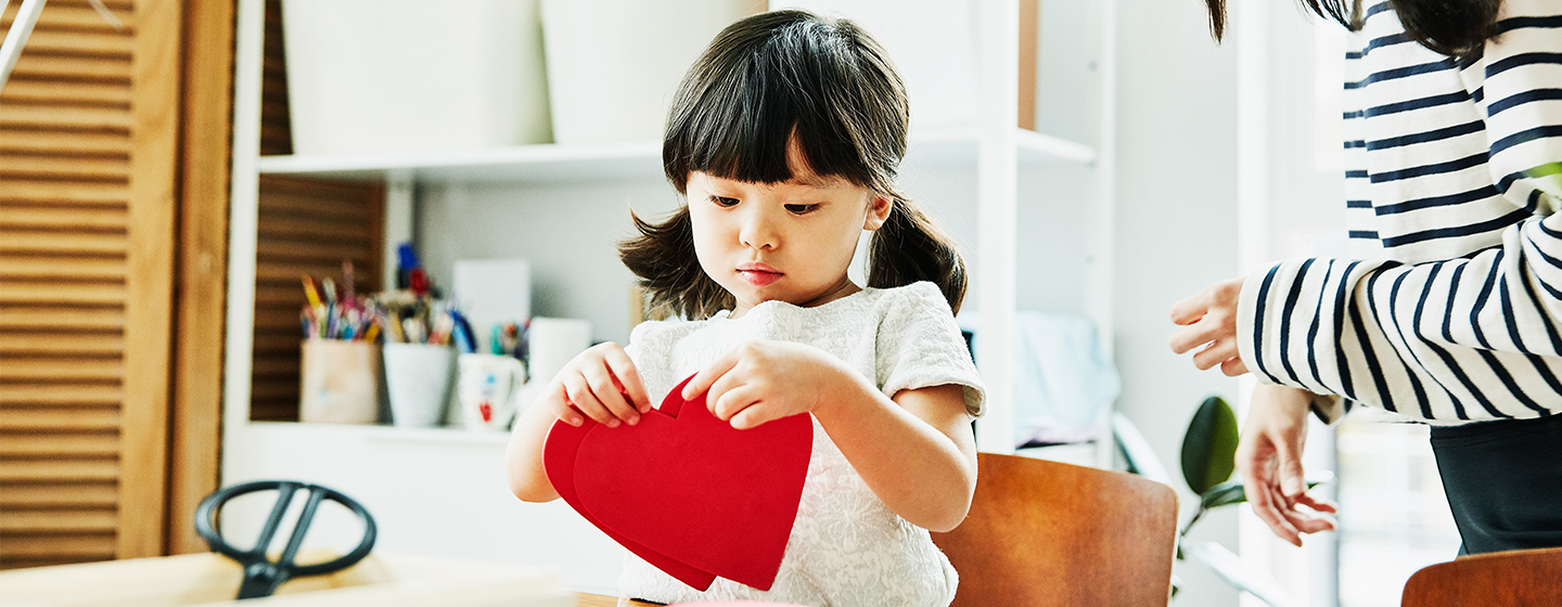 girl making heart shaped craft