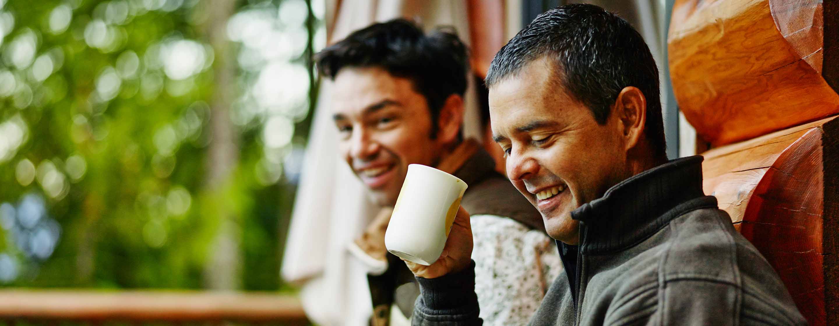 Two people having coffee on deck of cabin