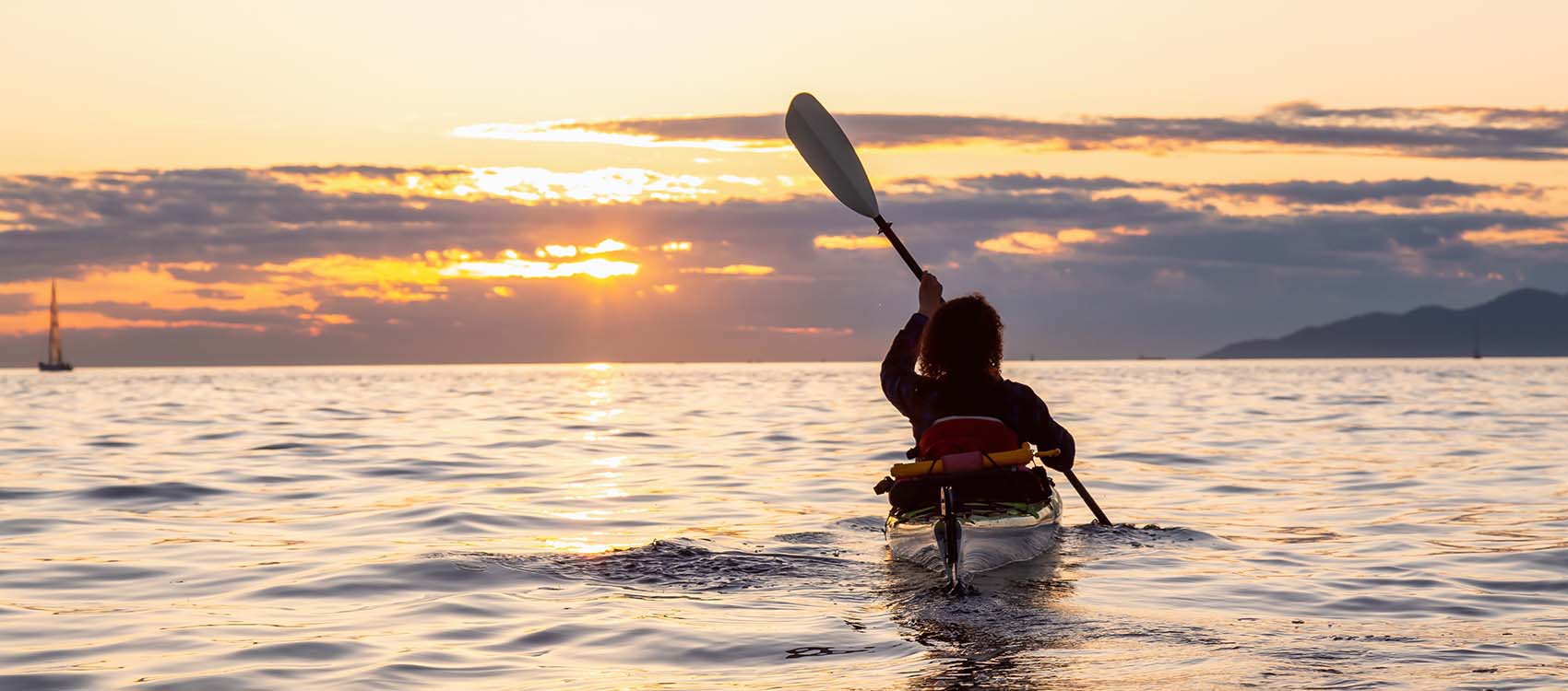 Kayaking during a vibrant sunny summer sunset in Vancouver, BC, Canada.