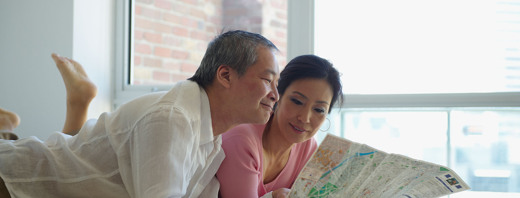 couple looking at map in bedroom
