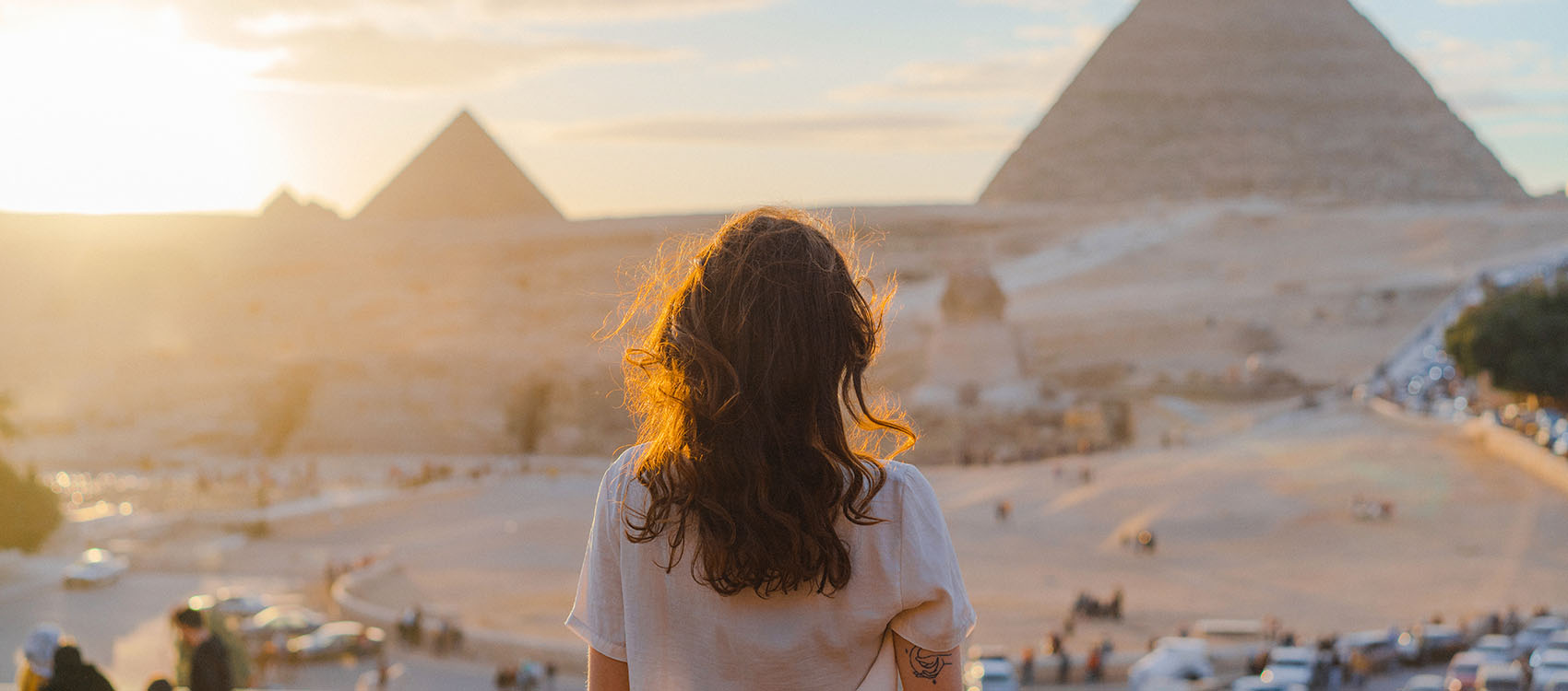 Woman standing on the terrace on the background of Giza pyramids