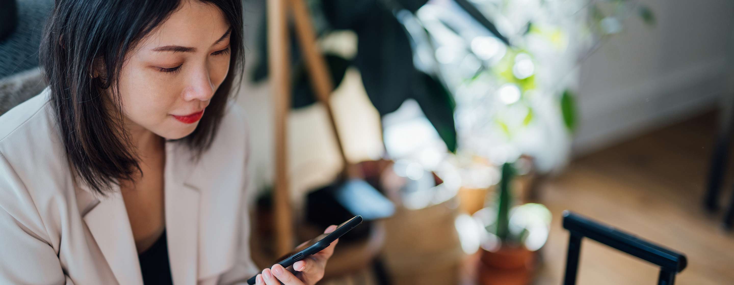 woman using mobile phone at home with luggage on the side