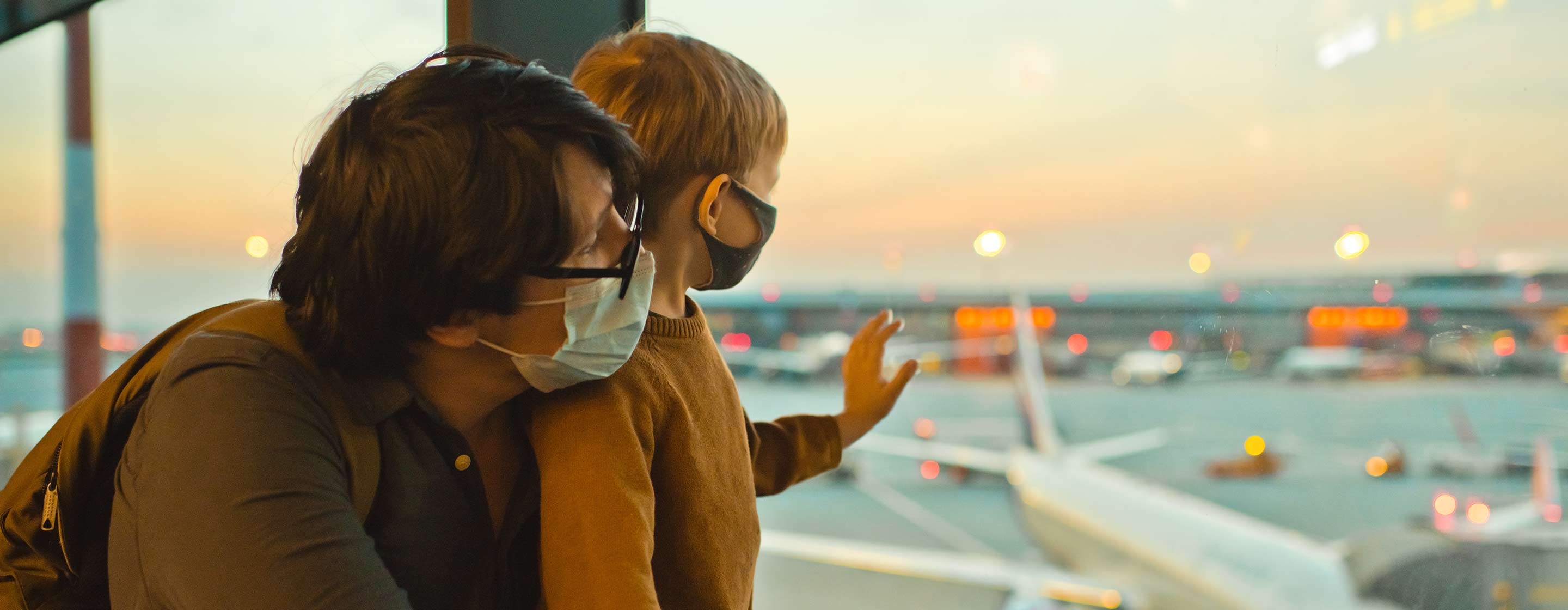Family in protective face masks in airport during COVID-19 pandemic