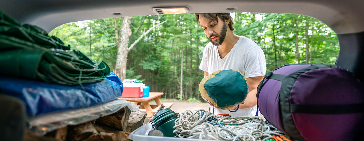 man packing camping gear