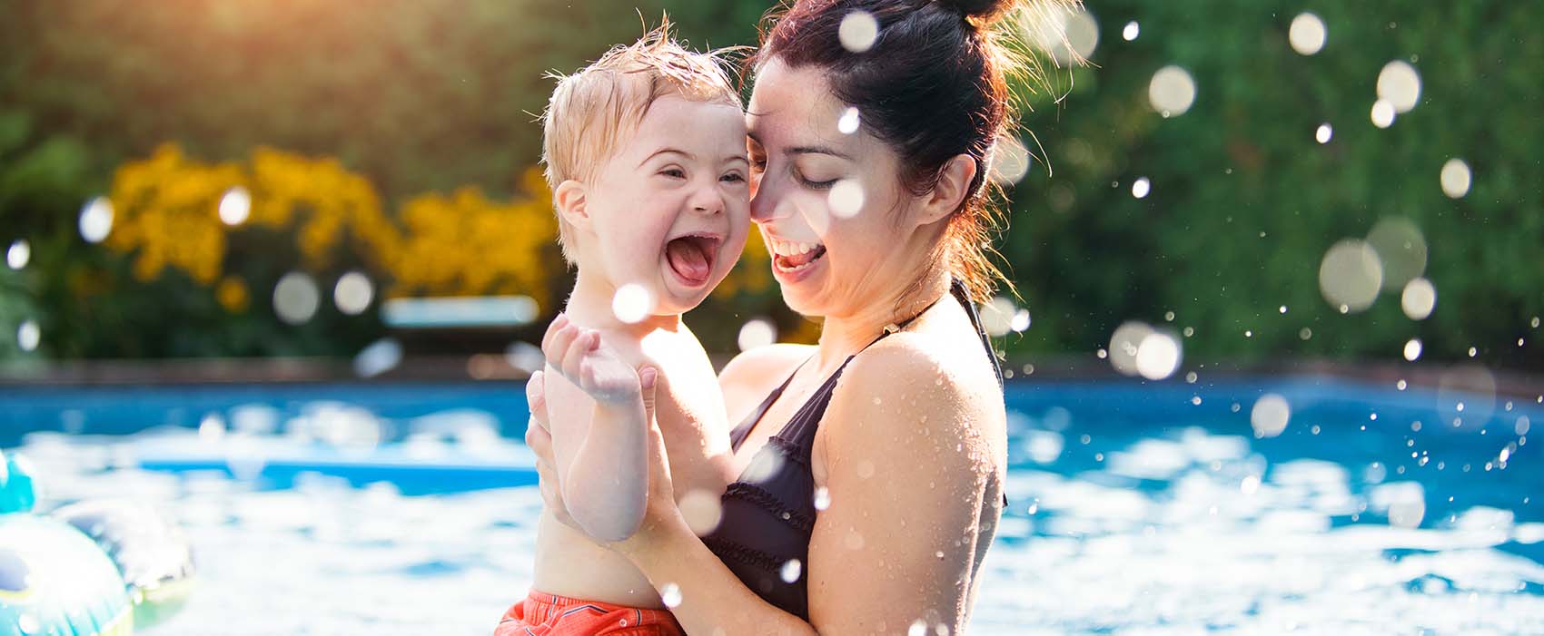 Little boy having fun in the swimming pool with his mother