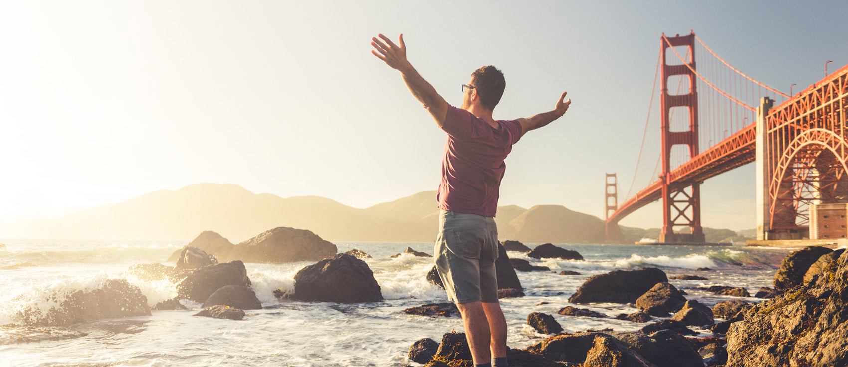 man standing by a river enjoying the sun