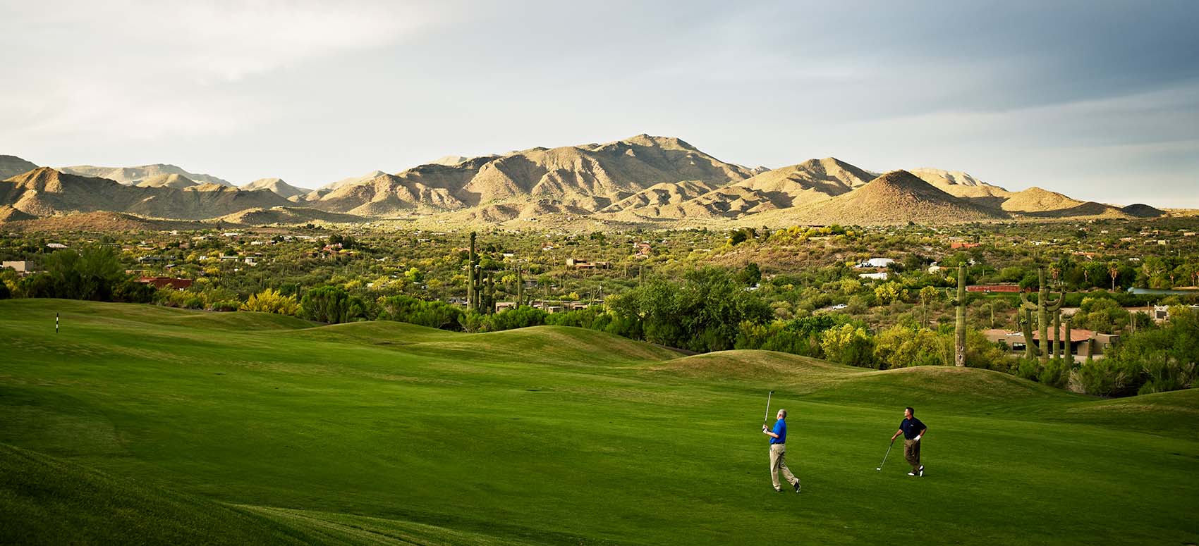 two golfers playing on fairway of golf course