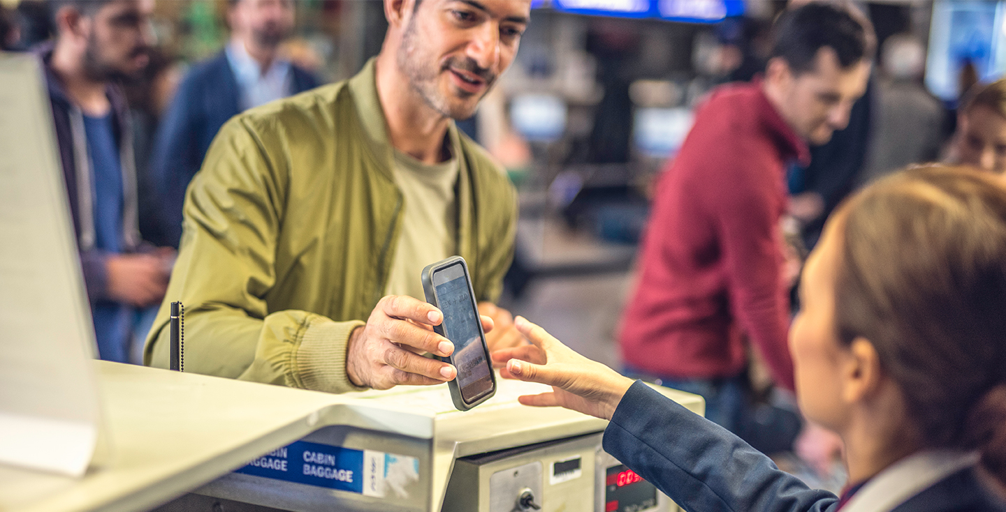 passenger showing phone to airport staff