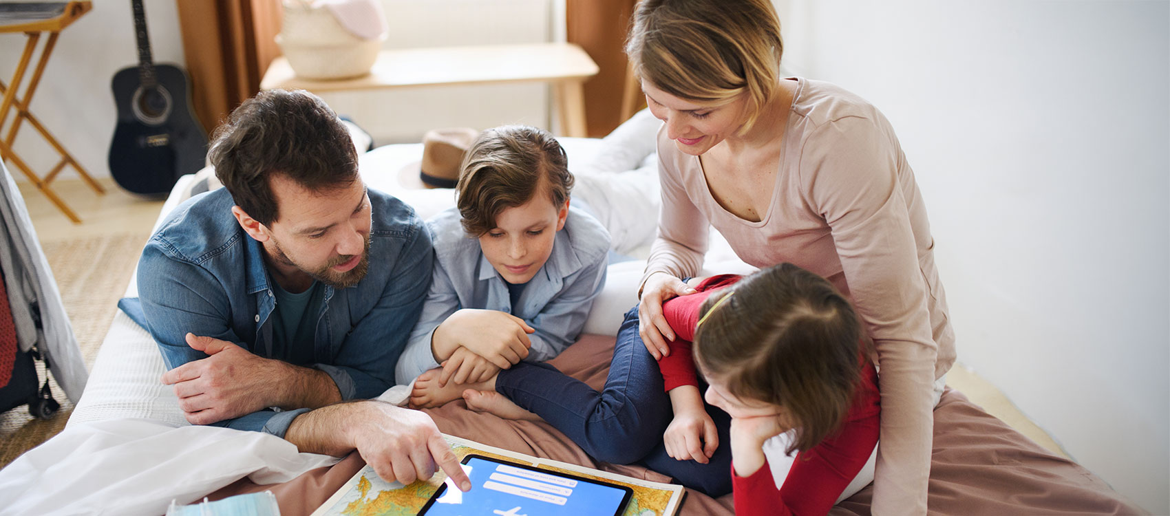 Family with young children at home planning summer holiday