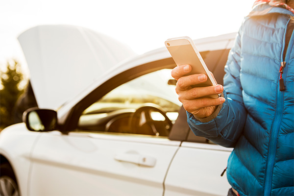 driver with broken down car on call with roadside assistance